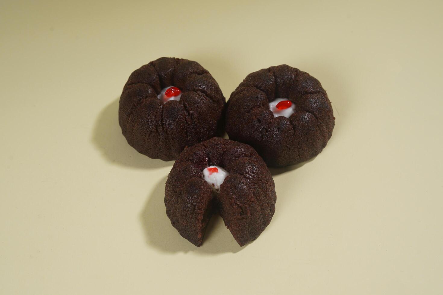 steamed brownie cake with a layer of red and white cream in the middle, isolated on yellow background photo