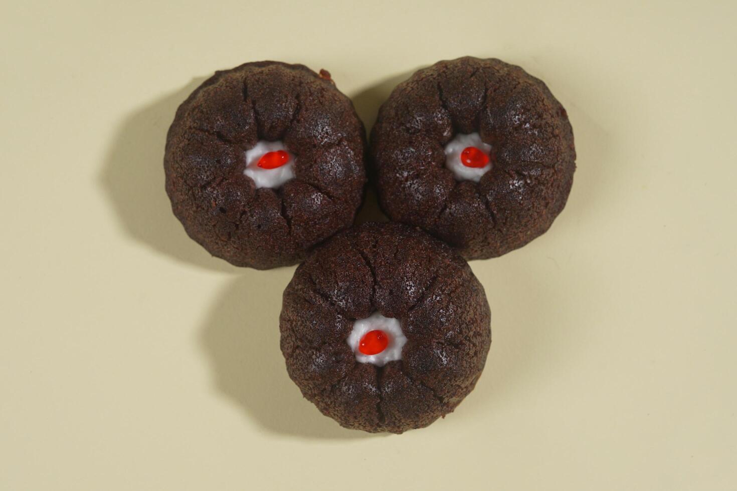 steamed brownie cake with a layer of red and white cream in the middle, isolated on yellow background photo