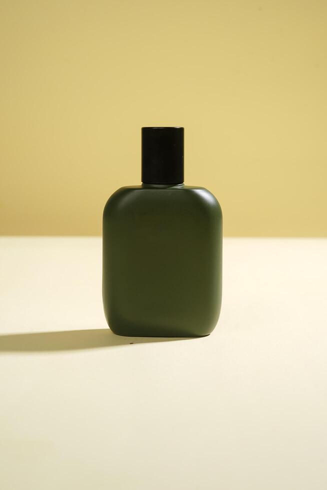 Perfume bottle with black spray on yellow background. High resolution photo. photo