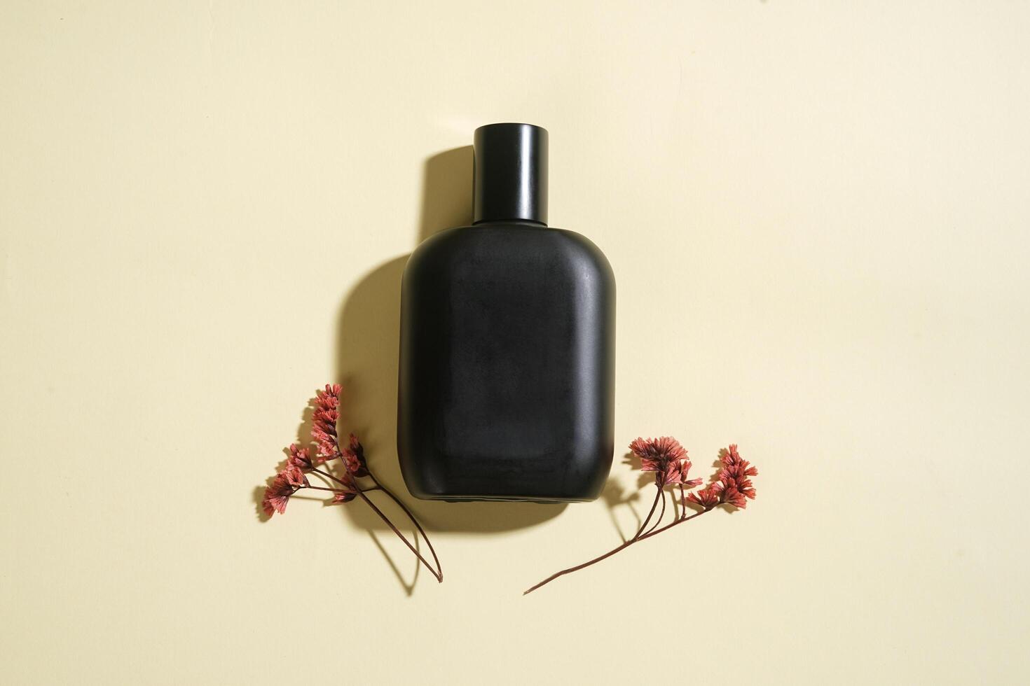 Perfume bottle with black spray on yellow background. High resolution photo. photo
