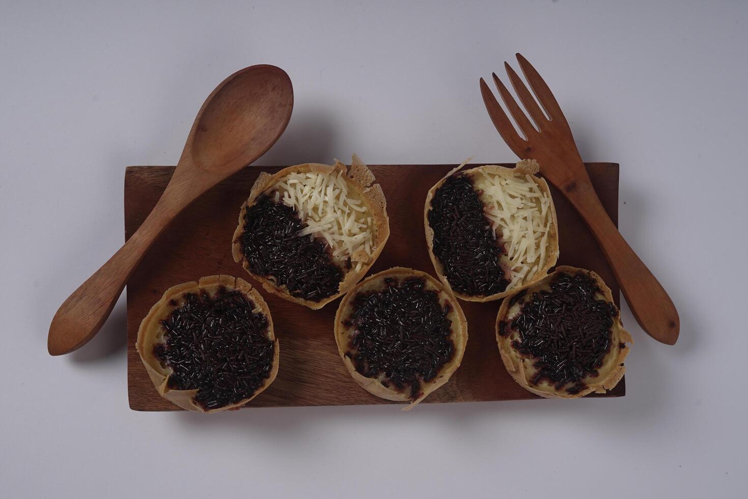 Martabak mini or terang bulan mini is Indonesian popular street food, made from flour, egg, yeast, topped with cheese or chocolate. Mini sweet martabak isolated on white background. photo