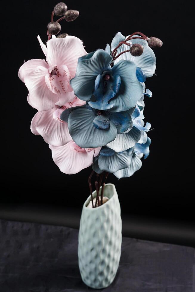 Pink and grey spring flowers in a vase on black background. High resolution photo. Selective focus. photo