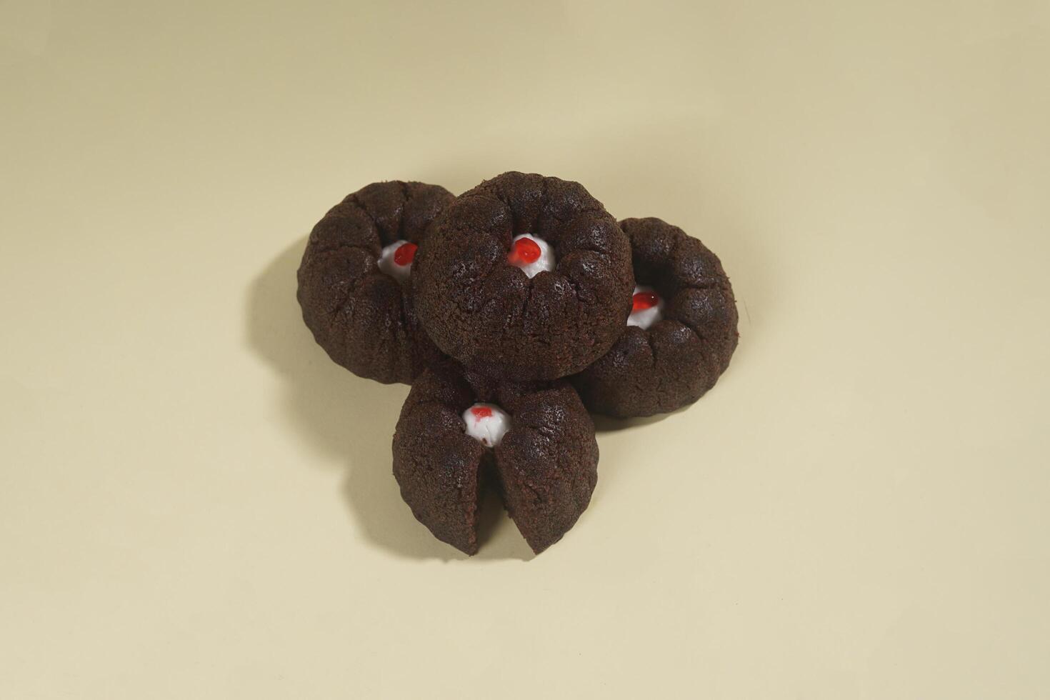 steamed brownie cake with a layer of red and white cream in the middle, isolated on yellow background photo