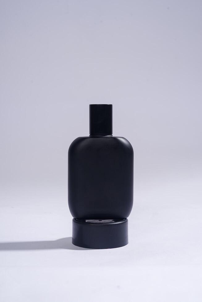 Perfume bottle with black spray on white background. High resolution photo. photo