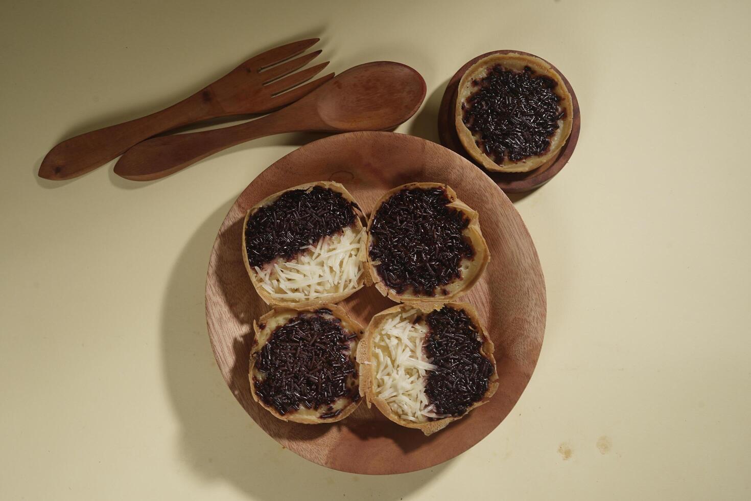 Martabak mini or terang bulan mini is Indonesian popular street food, made from flour, egg, yeast, topped with cheese or chocolate. Mini sweet martabak isolated on yellow background. photo