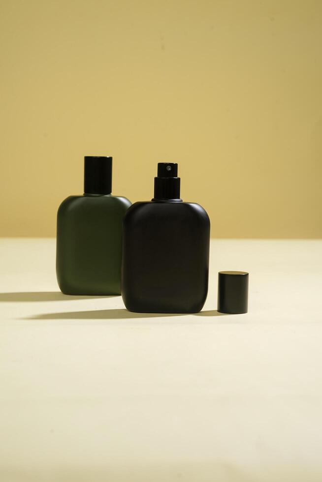 Perfume bottle with black spray on yellow background. High resolution photo. photo