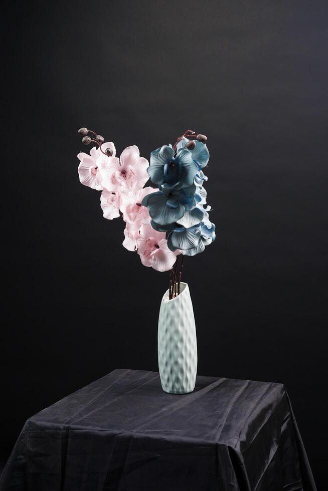 Pink and grey spring flowers in a vase on black background. High resolution photo. Selective focus. photo