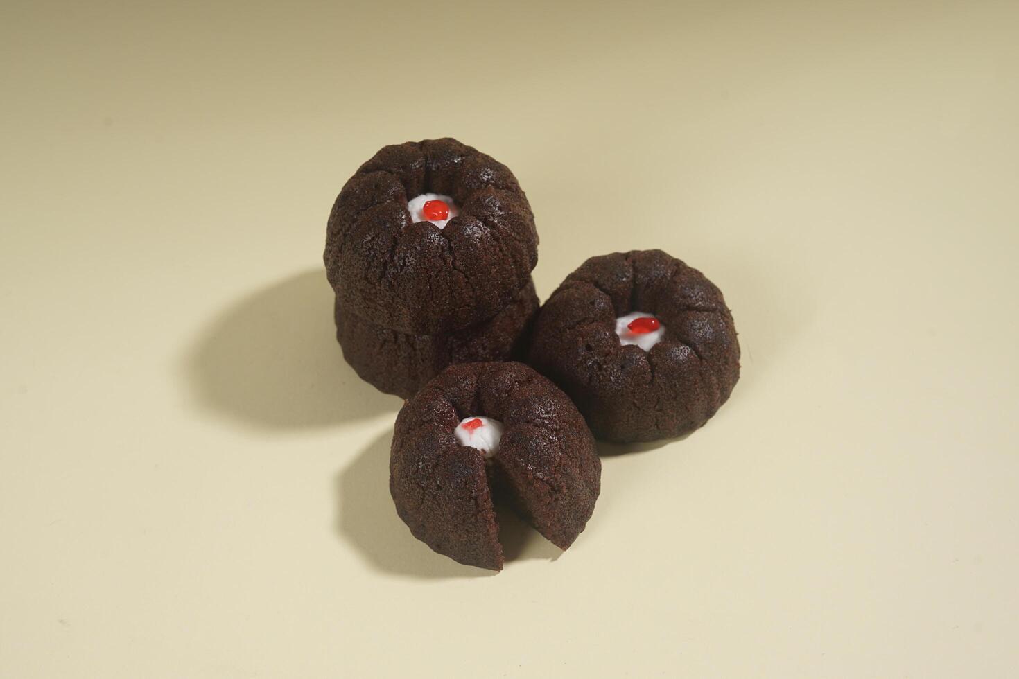 steamed brownie cake with a layer of red and white cream in the middle, isolated on yellow background photo