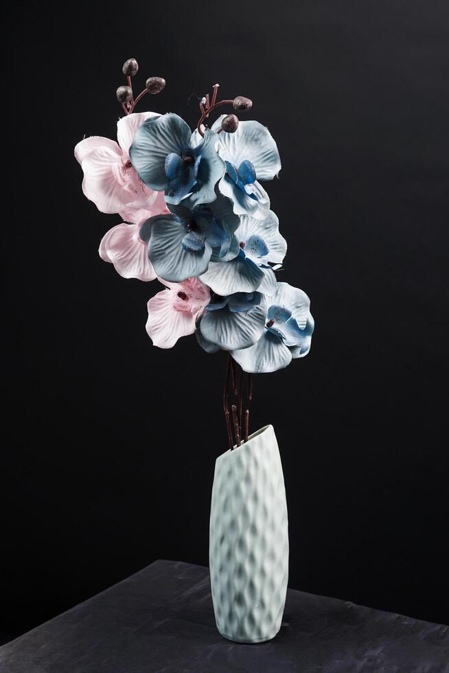 Pink and grey spring flowers in a vase on black background. High resolution photo. Selective focus. photo