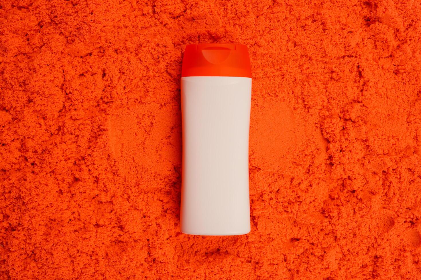 Plastic shampoo bottle with flip-top lid isolated on orange sand background. MockUp template for your design. Empty and clean packaging for cosmetic product. File contains clipping path. photo