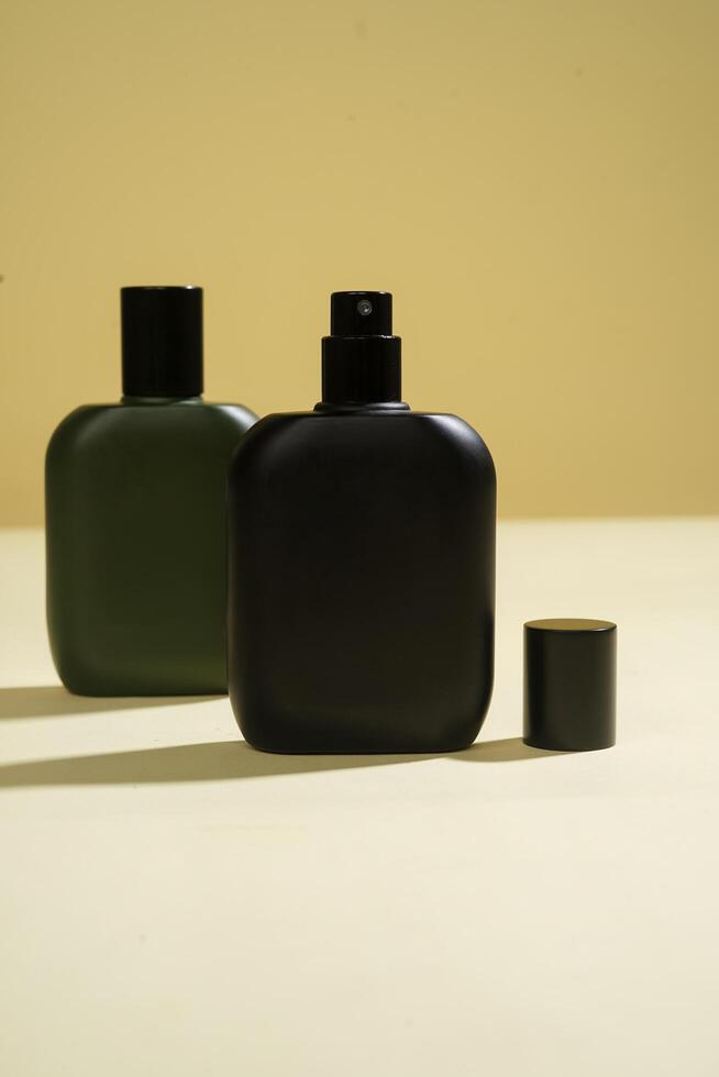 Perfume bottle with black spray on yellow background. High resolution photo. photo