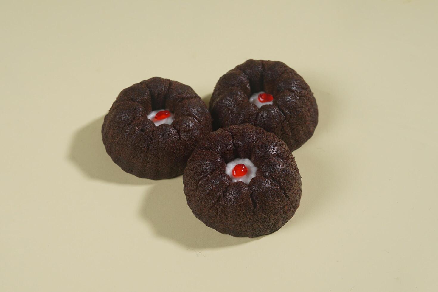 steamed brownie cake with a layer of red and white cream in the middle, isolated on yellow background photo