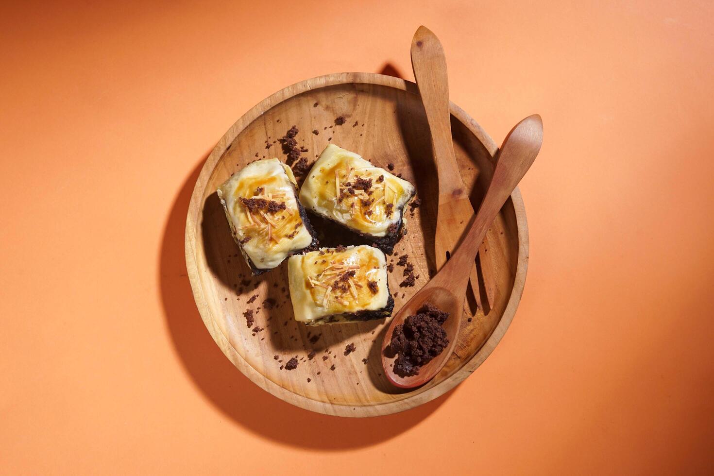 Banana Bolen is made from bananas and pastry dough, filled with chocolate and cheese. It is served on a wooden plate in a selective focus style image. photo