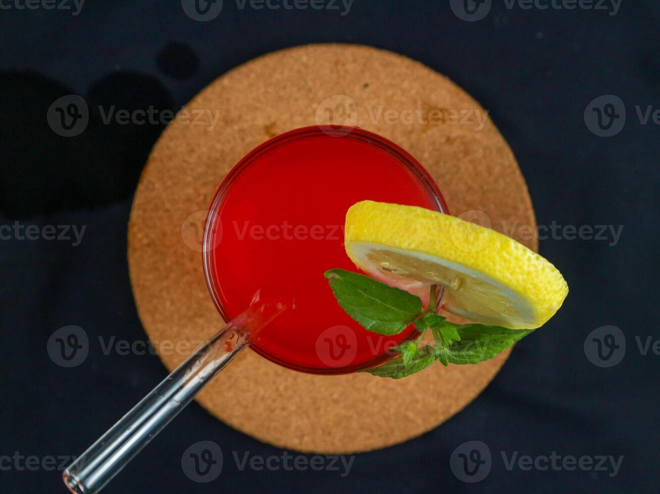 Top view, A glass of red drink with a mint leaves and orange on top, black background photo