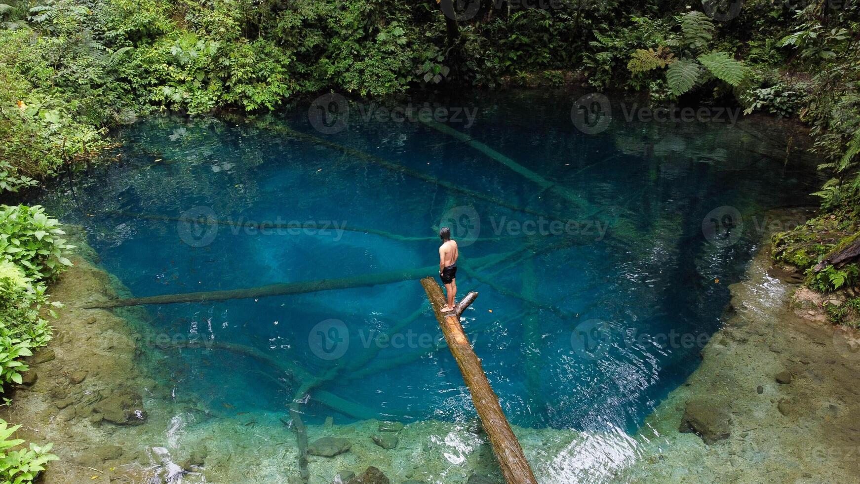 Aerial view of Lake Kaco, or Blue Lake, in Kerinci reveals its crystal-clear waters surrounded by lush green foliage. Nestled deep within the dense jungle photo
