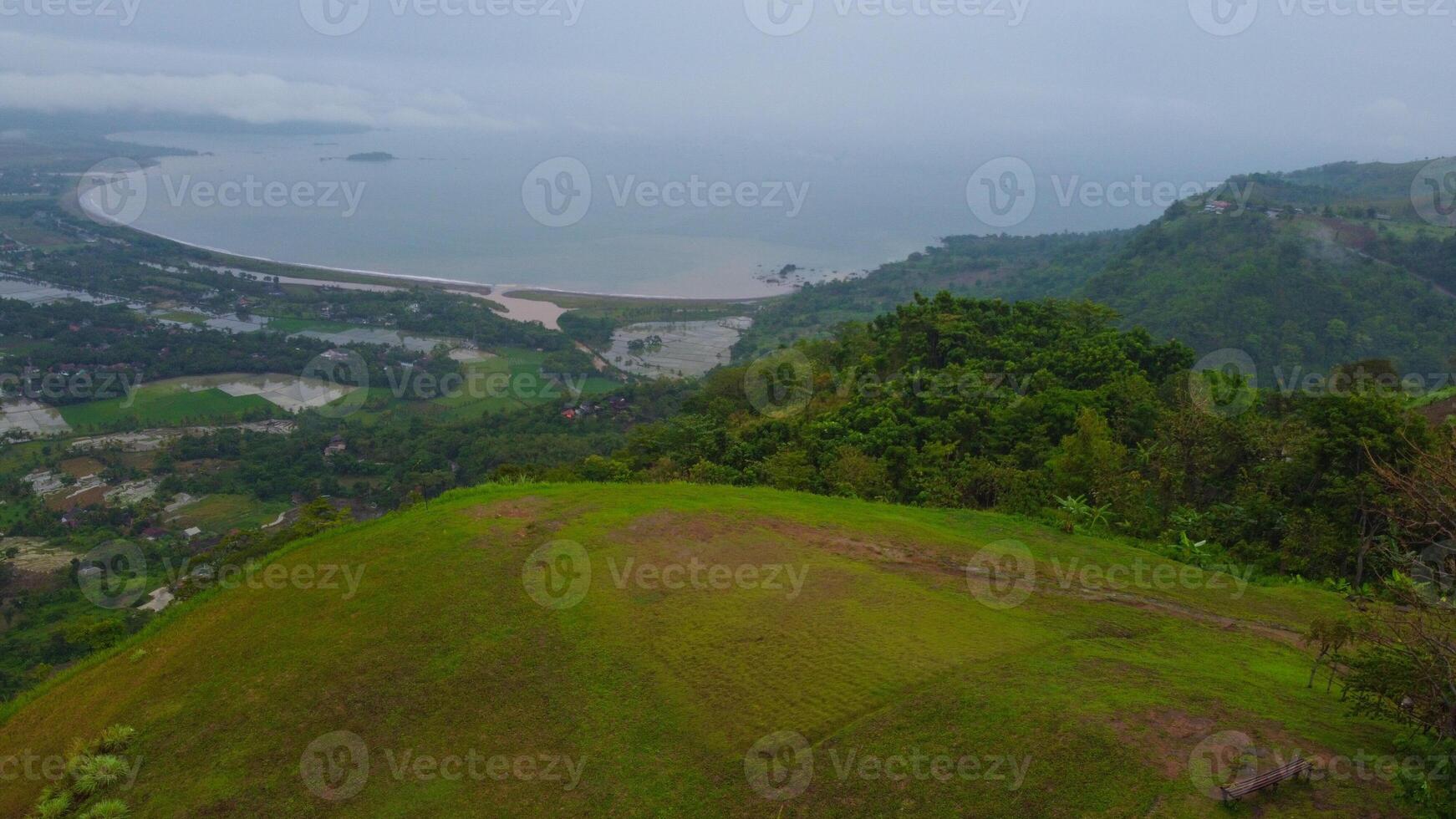 Aerial view of Ciletuh hill Sukabumi in tropical beach. no clear water and blue sky, hazy and cloudy. Pelabuhan Ratu Beach, Java Indonesia photo
