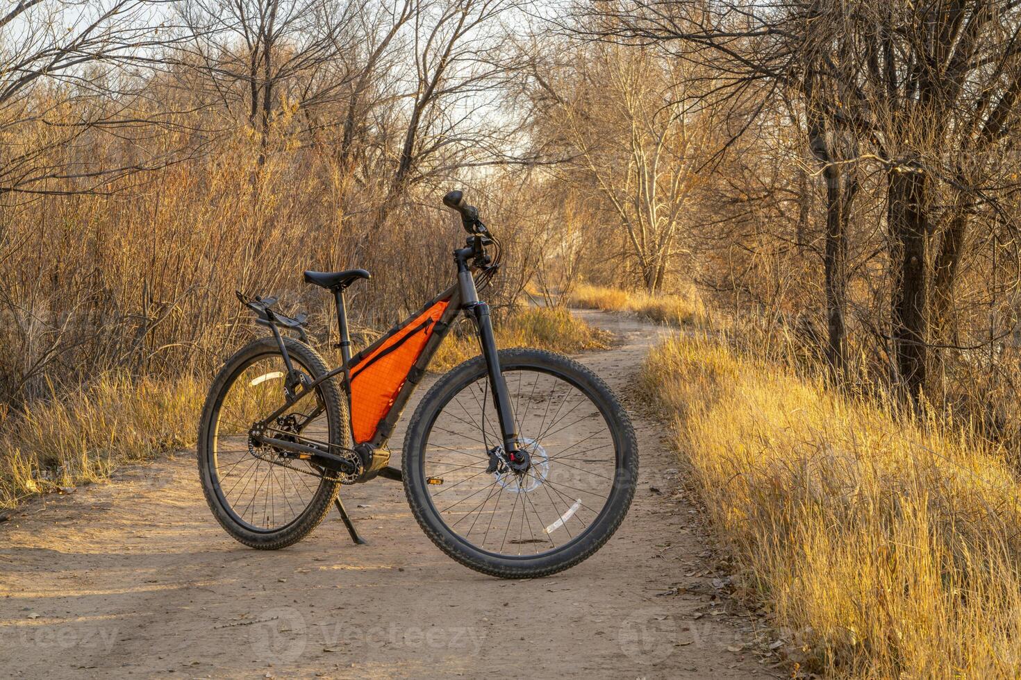 mountain bike on a gravel biking and hiking trail in one of natural areas in Fort Collins, Colorado, late fall scenery at sunset photo