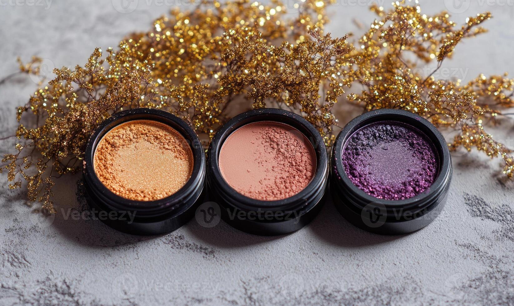 A set of four eyeshadows pale peach, dusty mauve, golden taupe, and dark purple, with golden tinsel accents photo