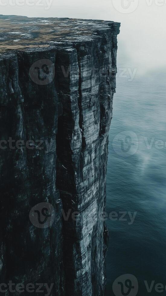 Cliff face dropping straight down to water below , photorealistic wallpaper photo