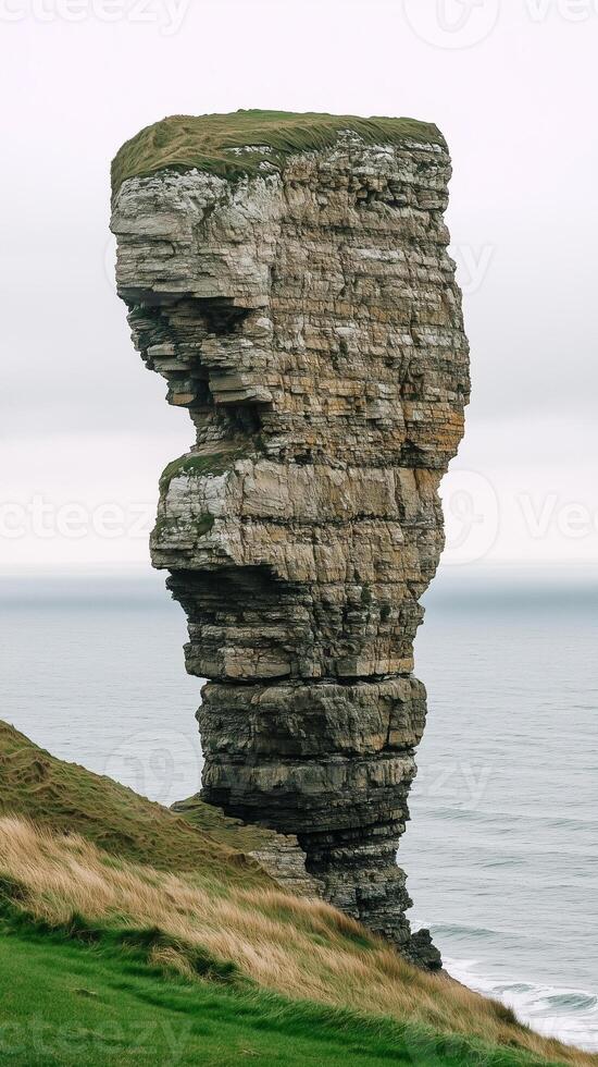 Rock stack standing apart from mainland cliff , photorealistic wallpaper photo