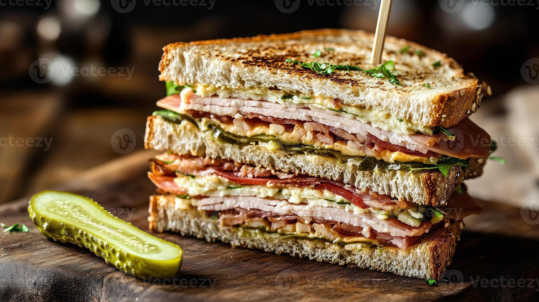 Club sandwich sliced open on a wooden surface with a pickle spear beside it, food photography photo
