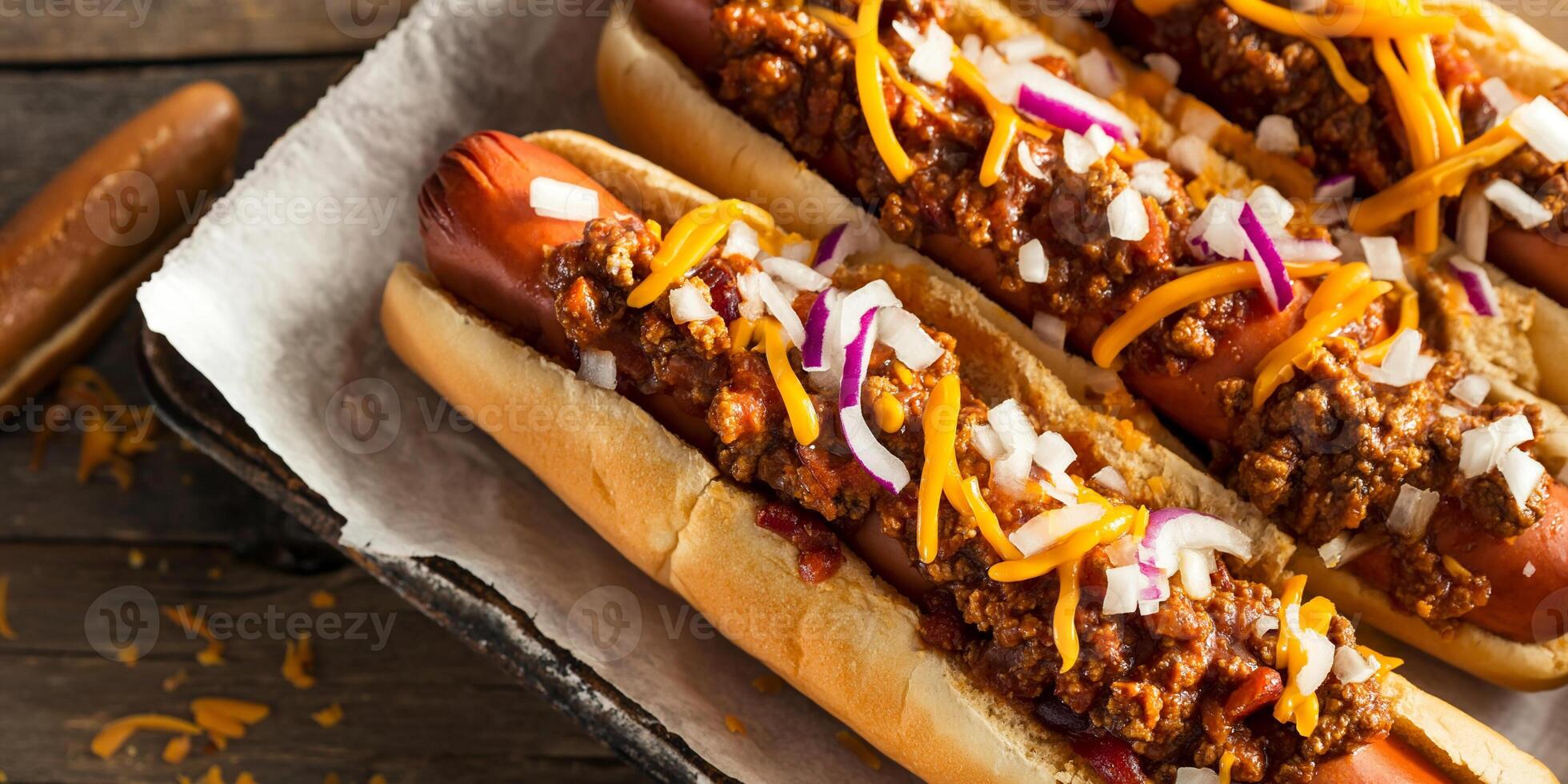 Chili dogs on a tray, topped with chili, cheese, and onions, culinary photography photo