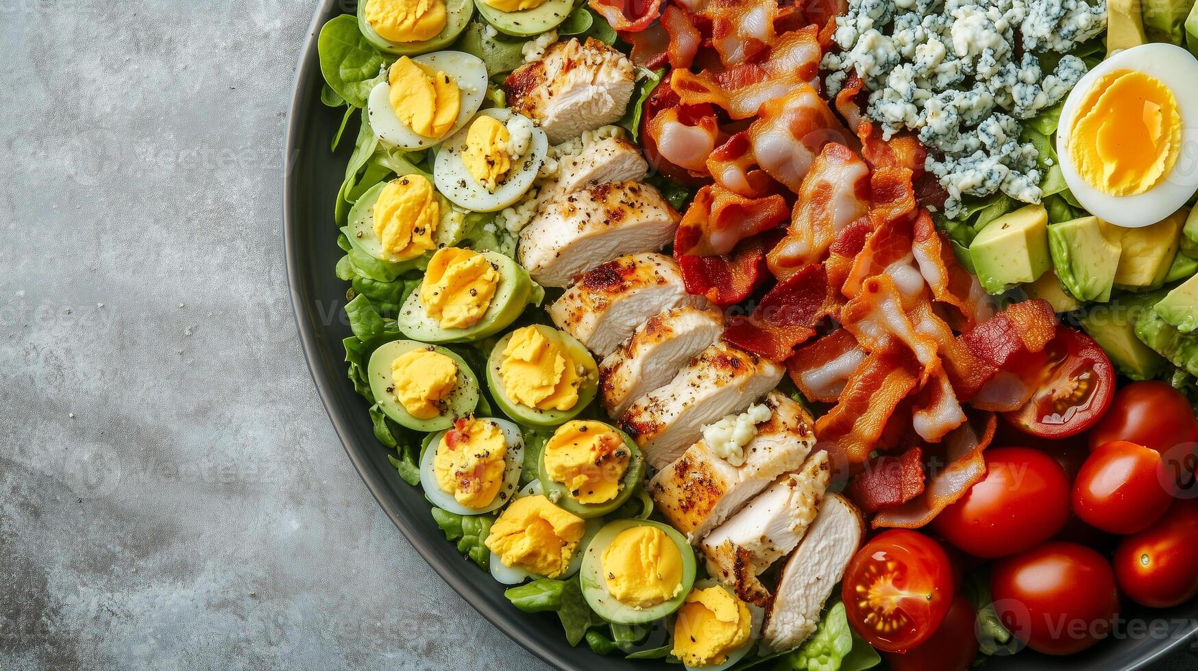 Cobb salad in a dish with rows of chicken, bacon, eggs, avocado, tomatoes, and blue cheese, gastronomy photography photo