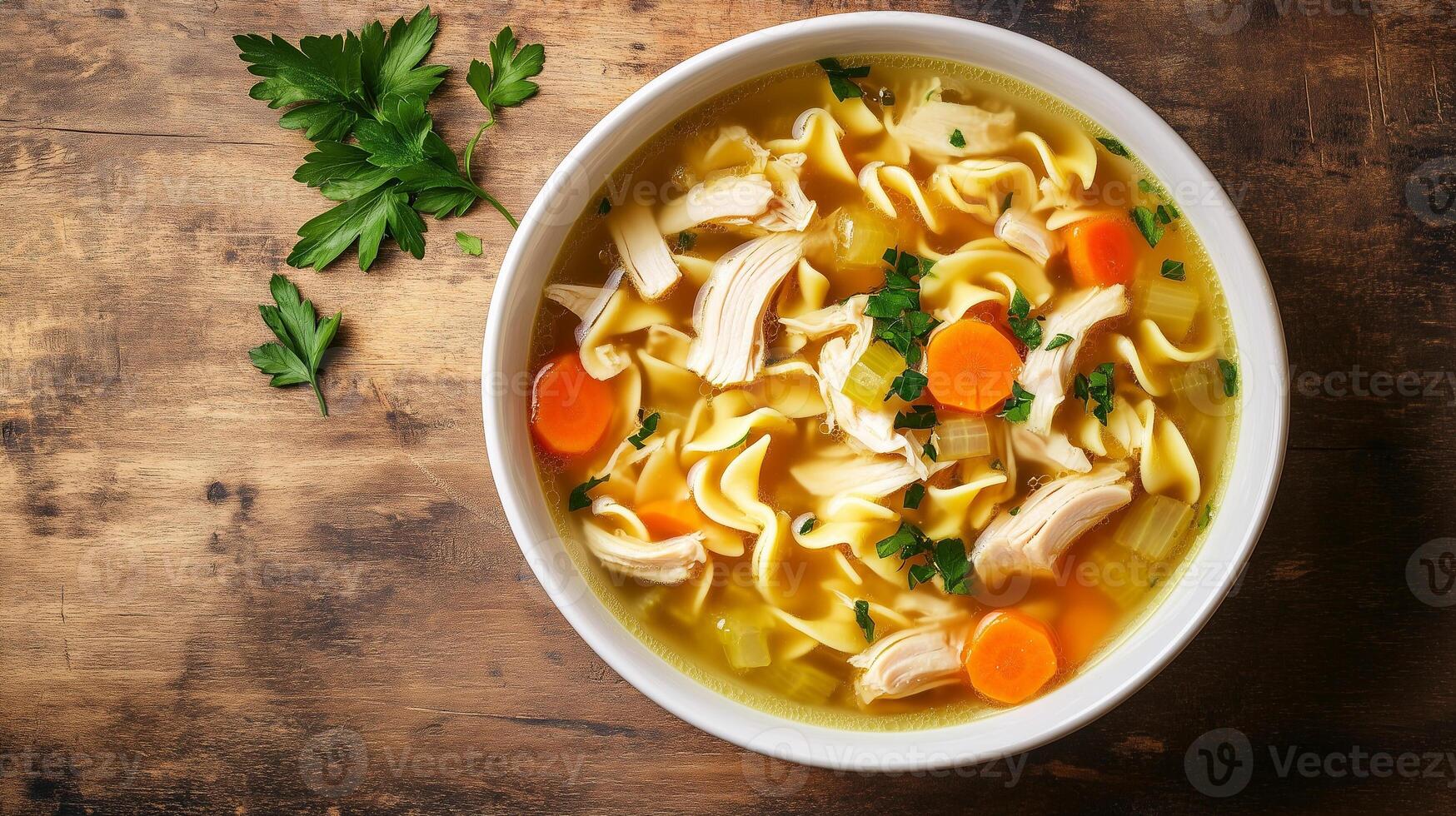 Bowl of chicken noodle soup with floating chicken, noodles, and vegetables, food setting photo