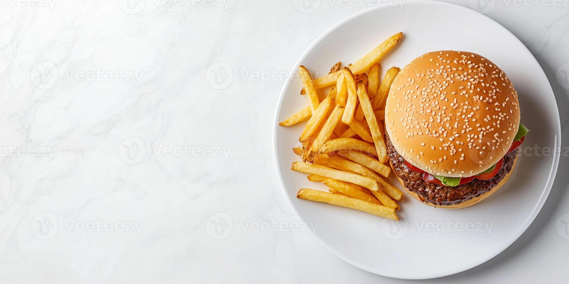 Burger placed next to a pile of fries on a white plate, meal photography photo