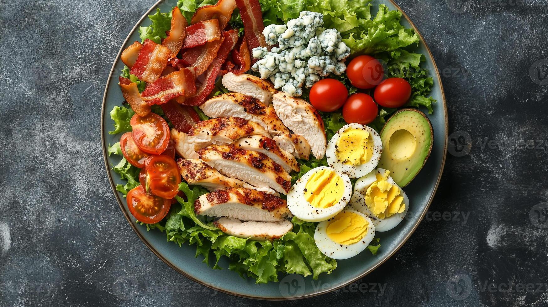 Cobb salad on a plate with rows of chicken, bacon, avocado, eggs, tomatoes, and blue cheese, meal photography photo
