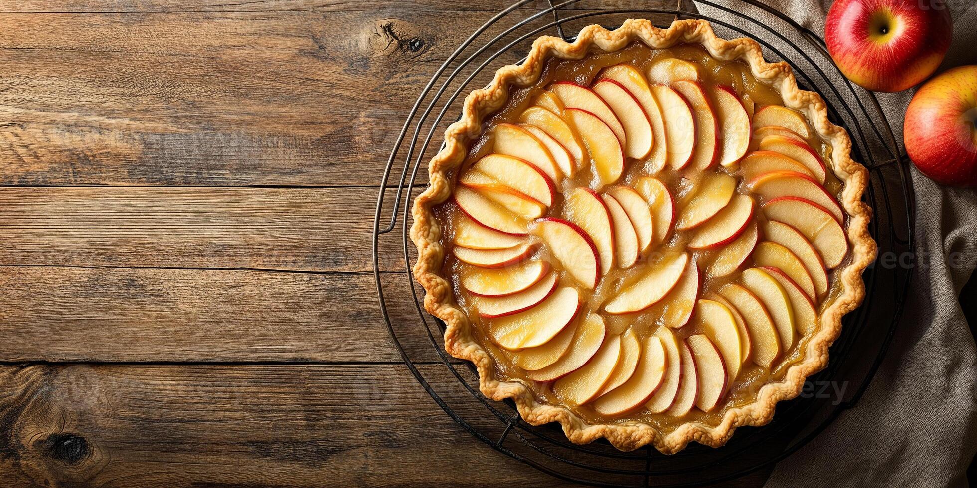 Pie with circular crust, filled with sliced apples, placed on cooling rack, food setting photo