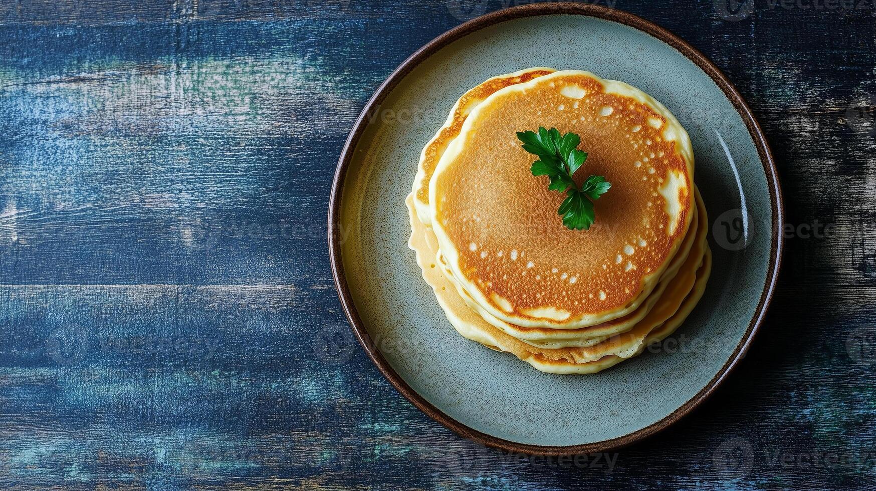 Plate with three stacked buttermilk pancakes in the center, food setting photo