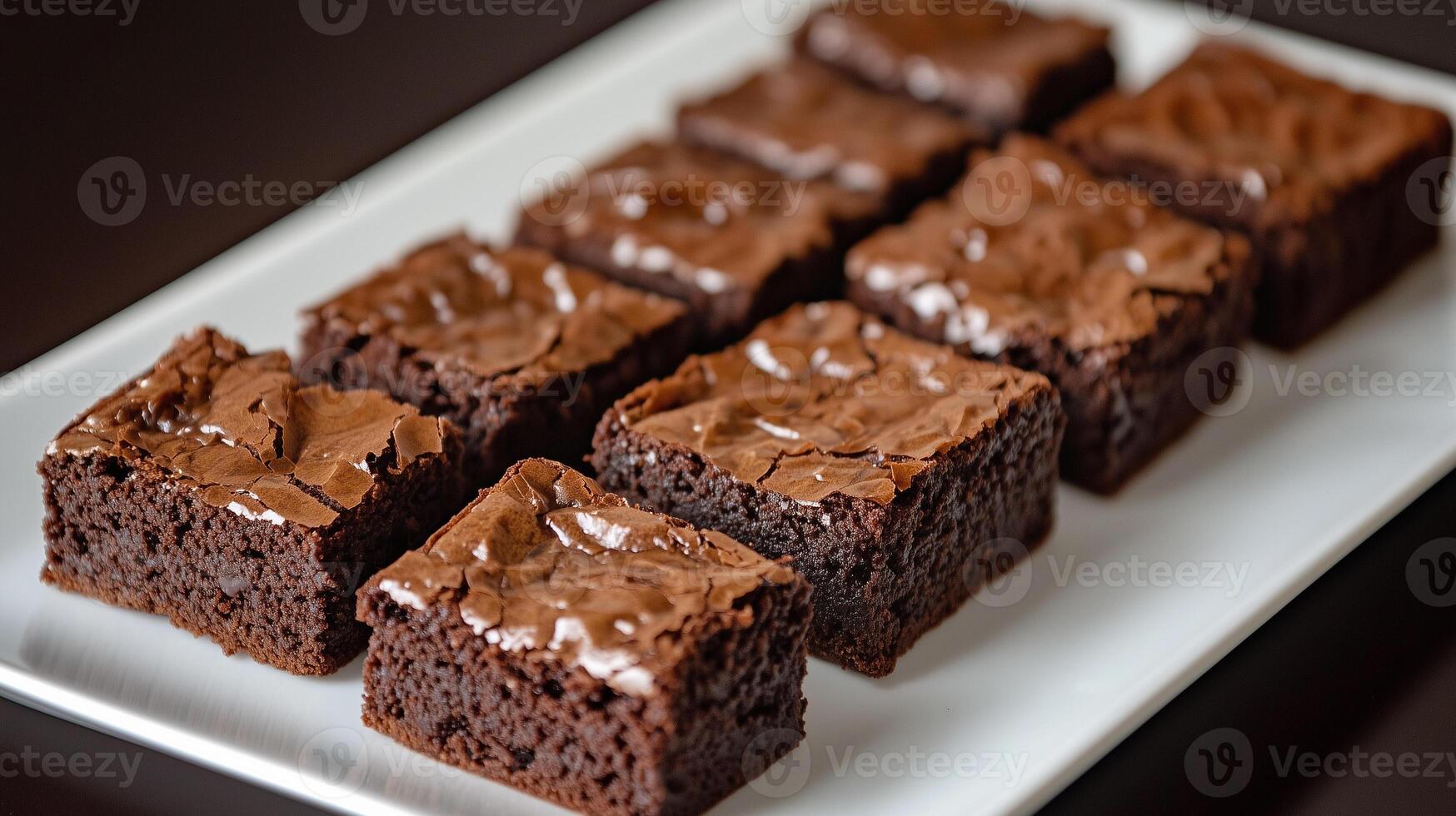 Row of brownie squares arranged on a rectangular serving platter, culinary photography photo