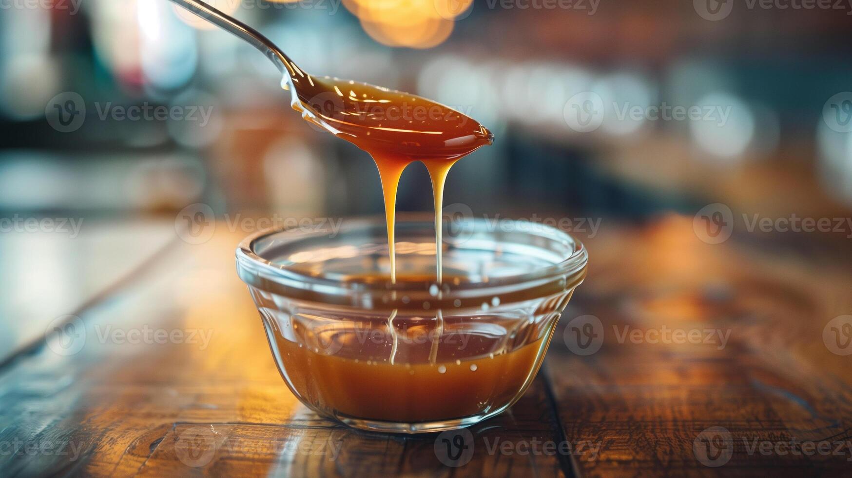 Spoonful of caramel sauce hovering above a small glass dish, gastronomy photography photo