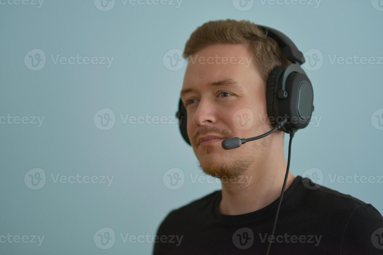 A man wearing headphones with microphone talking with colleges on a remote company conference. Professional expert speech photo
