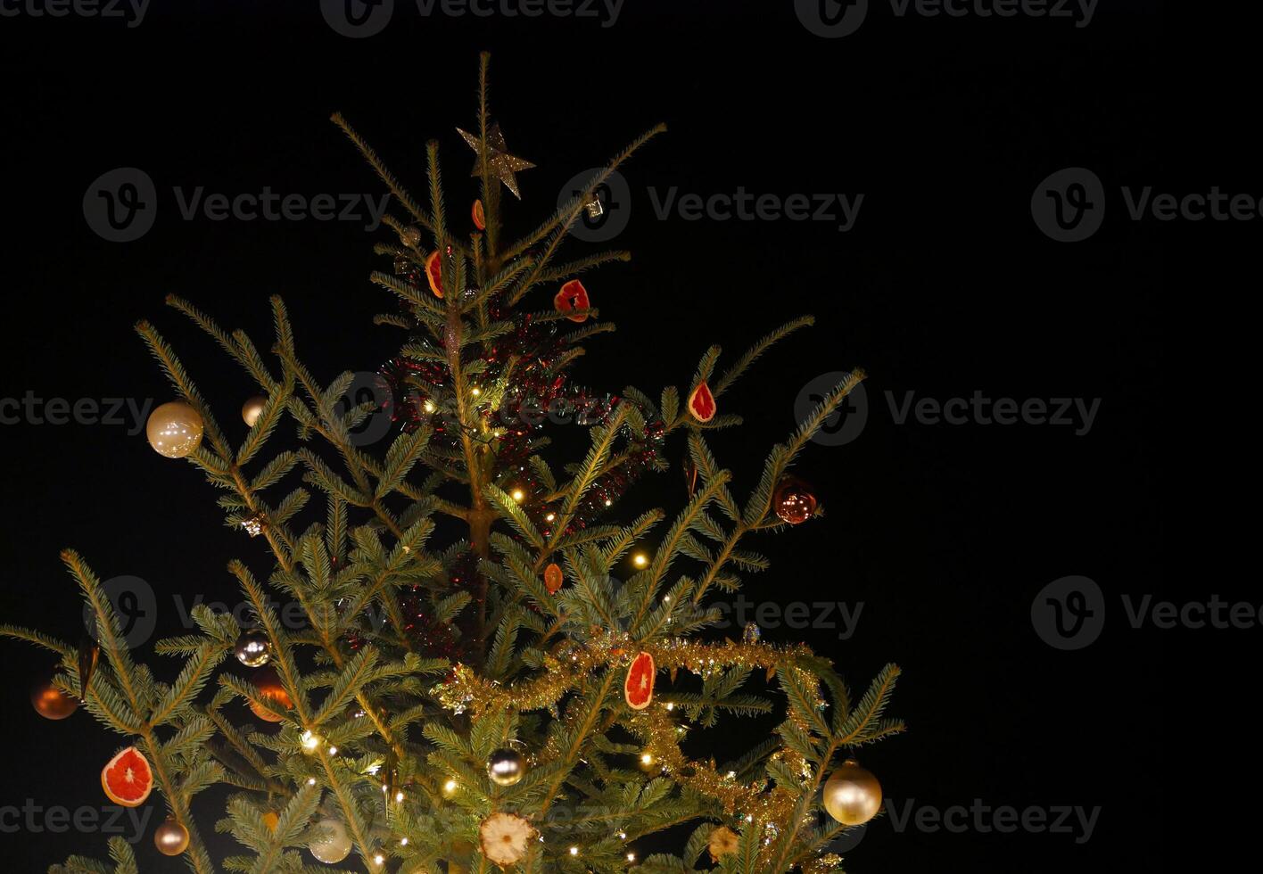 Christmas tree decorated with dried citrus fruits and a garland of lights photo