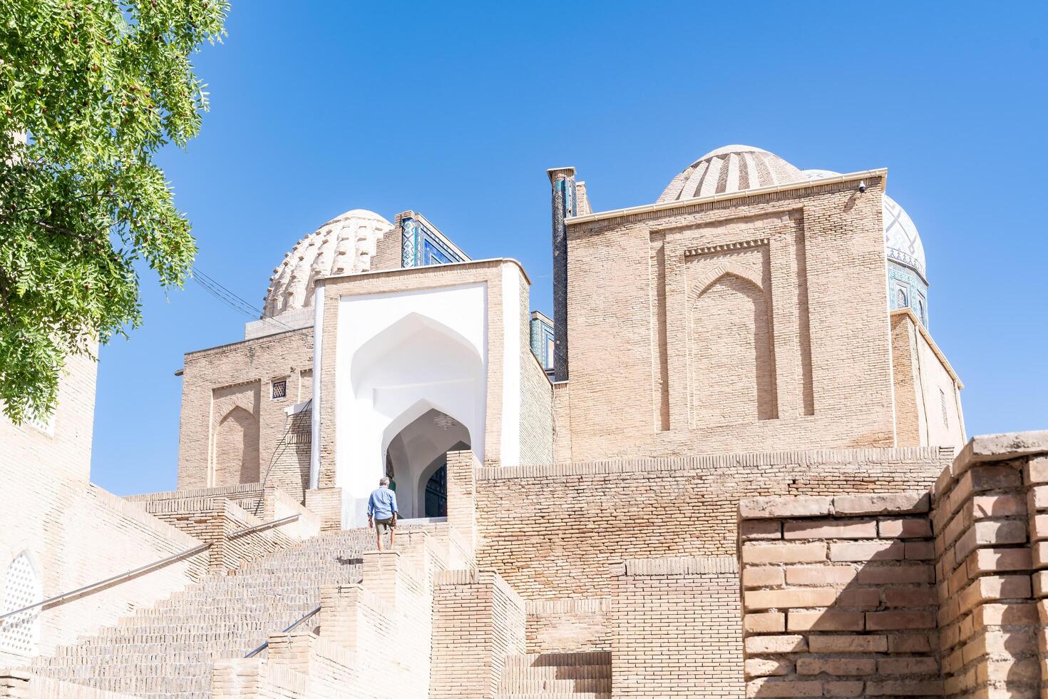 Samarkand, Uzbekistan-august 13, 2023-People visit Shakhi Zinda necropolis, a famous mausoleum complex in Samarkand during a sunny day photo