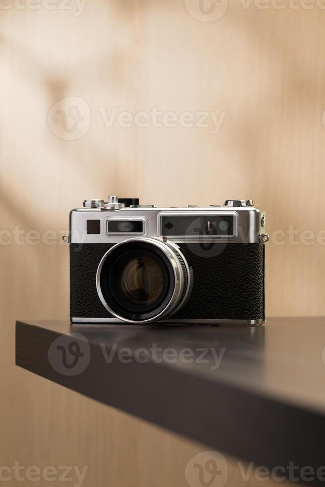 A vintage film camera sits elegantly on a table, showcasing timeless craftsmanship. photo