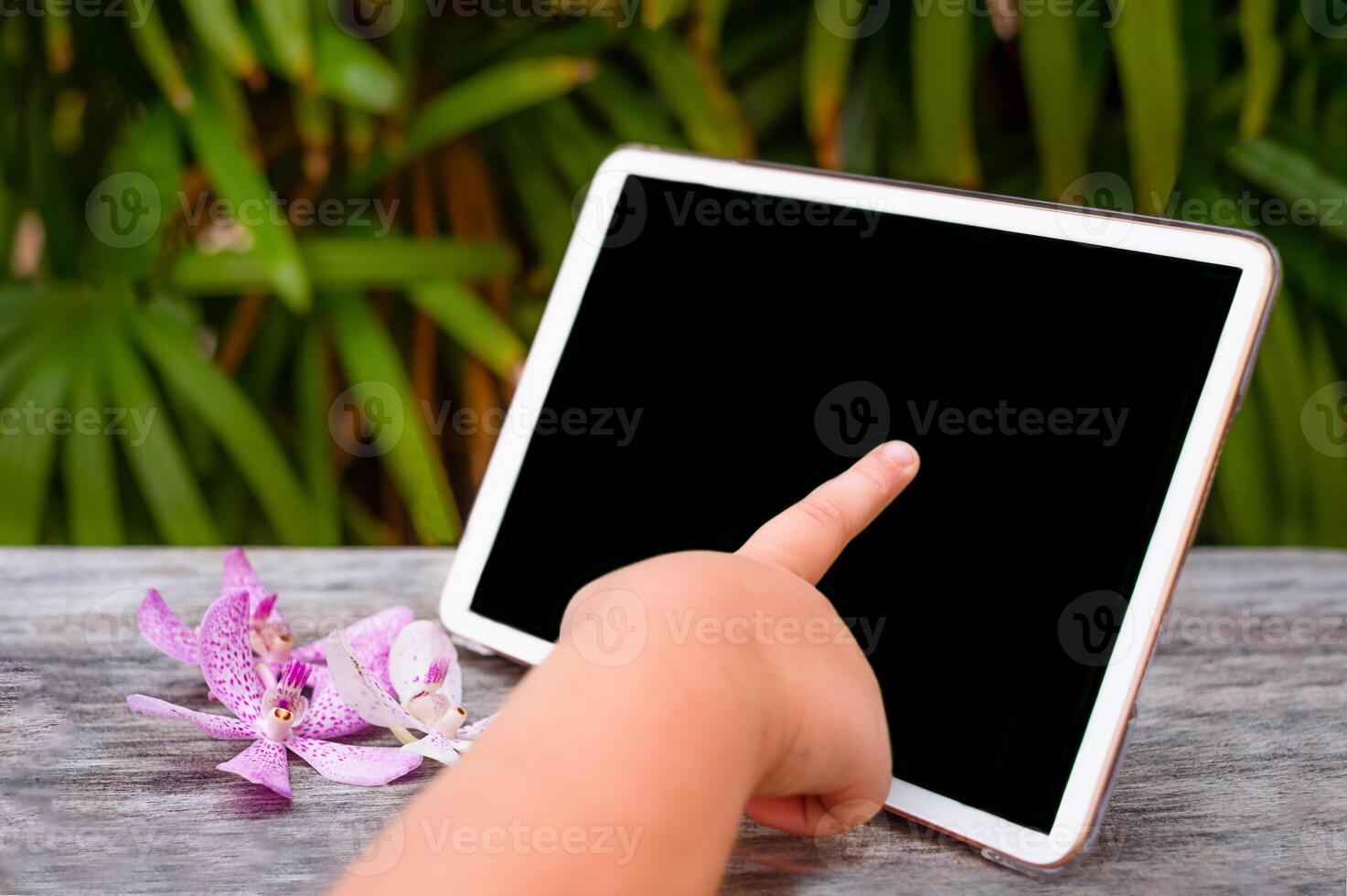 Child's hand touches the tablet photo