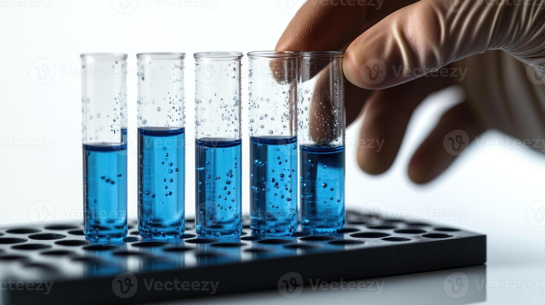 A lab technician meticulously focuses on transferring blue liquids between test tubes photo