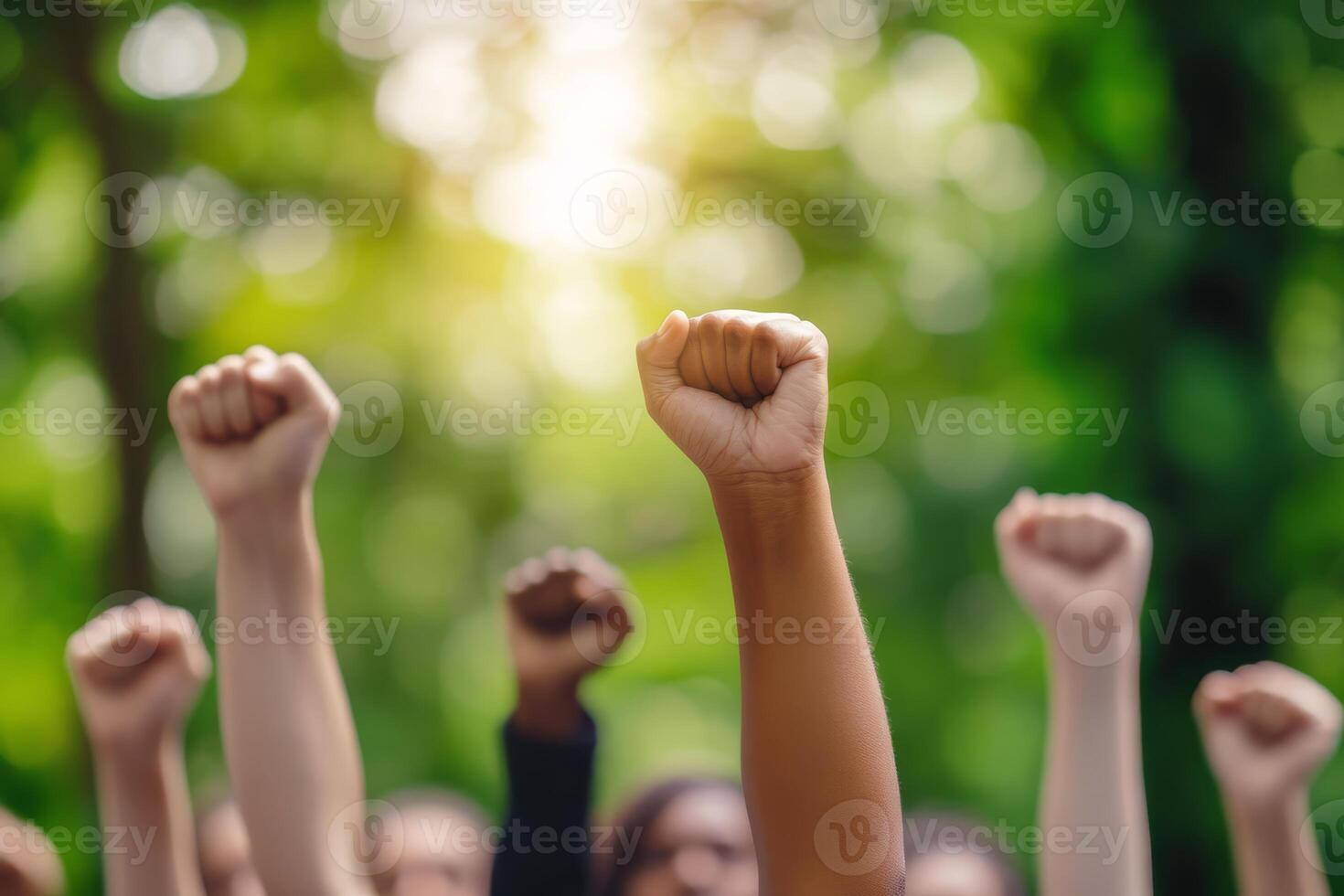 In a green park, a diverse group raises their fists in solidarity during a peaceful protest, symbolizing unity, strength, and hope for a brighter future where all thrive and embrace change photo