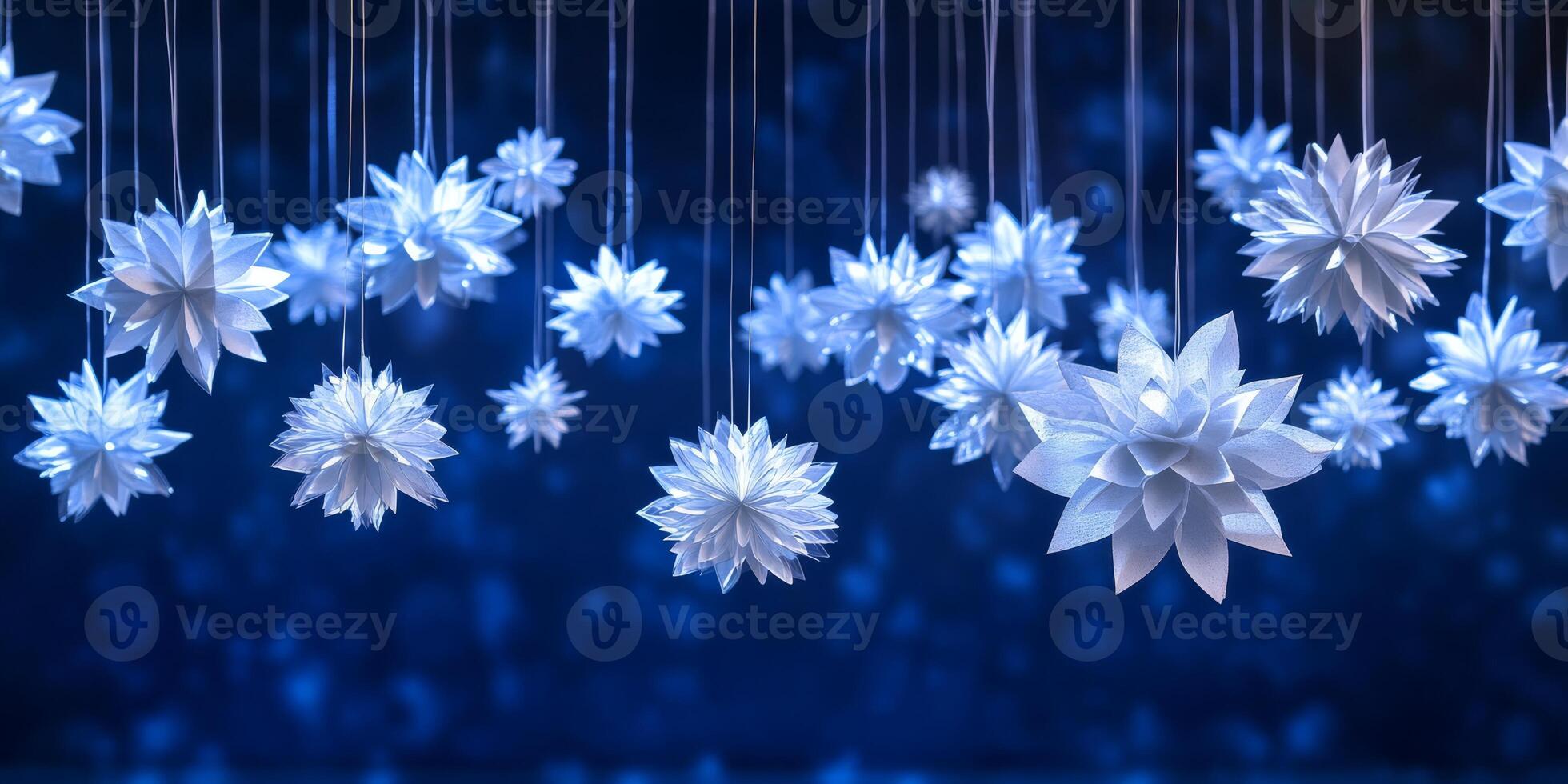 A mesmerizing and enchanting scene emerges, featuring delicate white paper snowflakes gracefully suspended against a rich deep blue backdrop, together creating an inviting winter wonderland ambiance photo