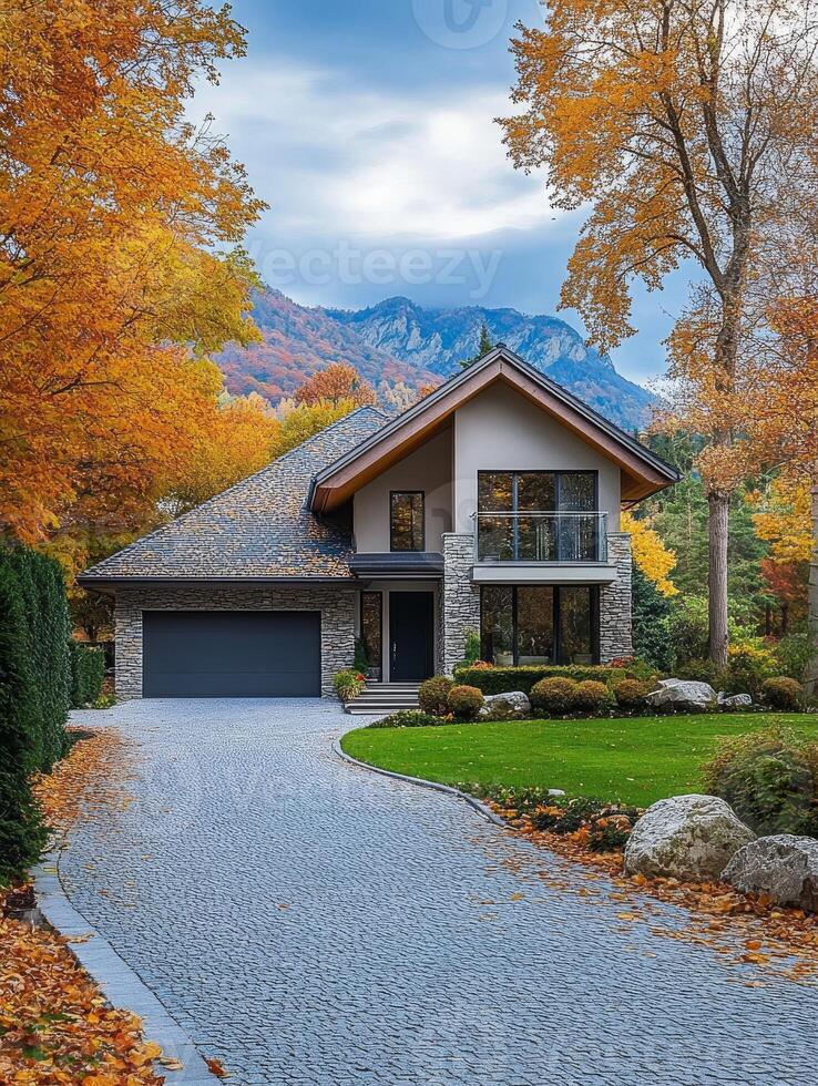 This beautiful house has a landscaped front yard and a gravel driveway, adding charm with autumn colors and a mountain backdrop, creating an inviting atmosphere in a peaceful neighborhood photo