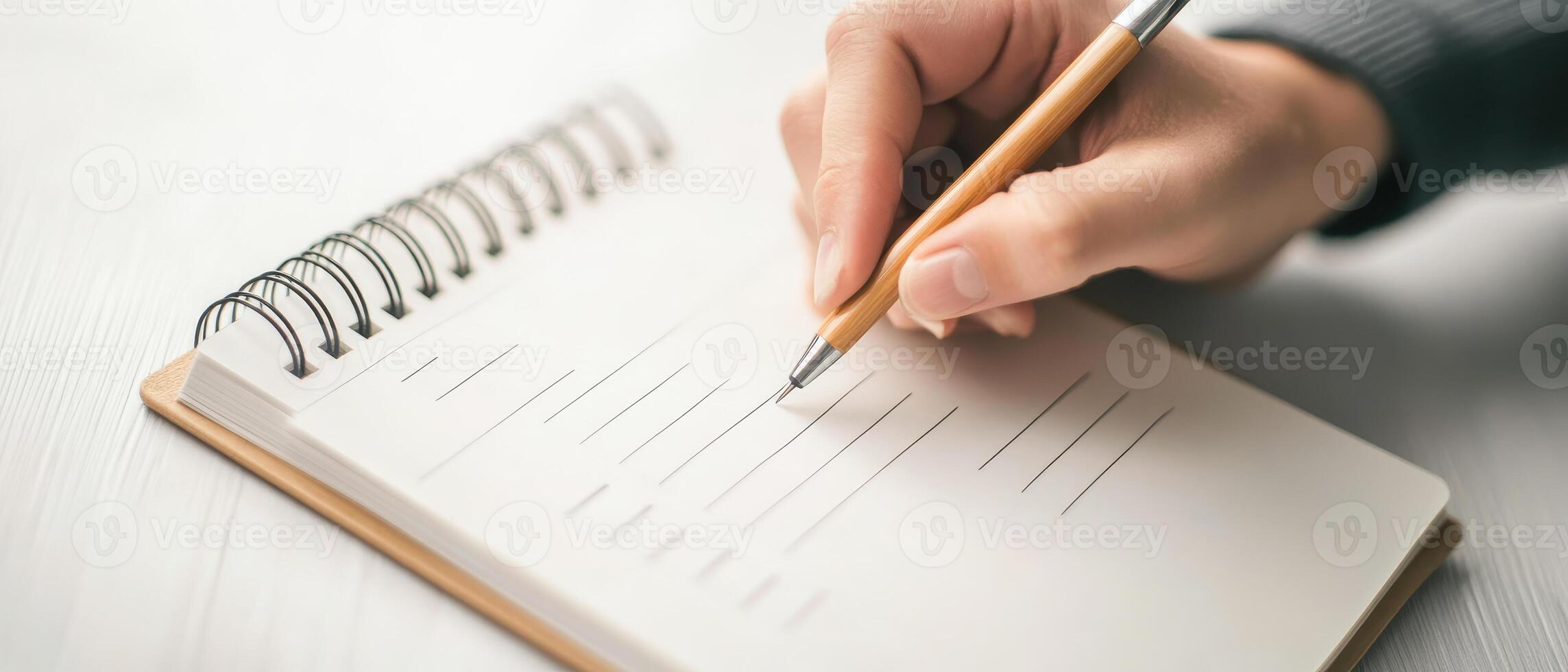 person writing in blank notebook with pen, focusing on organization and planning. scene conveys sense of productivity and creativity photo