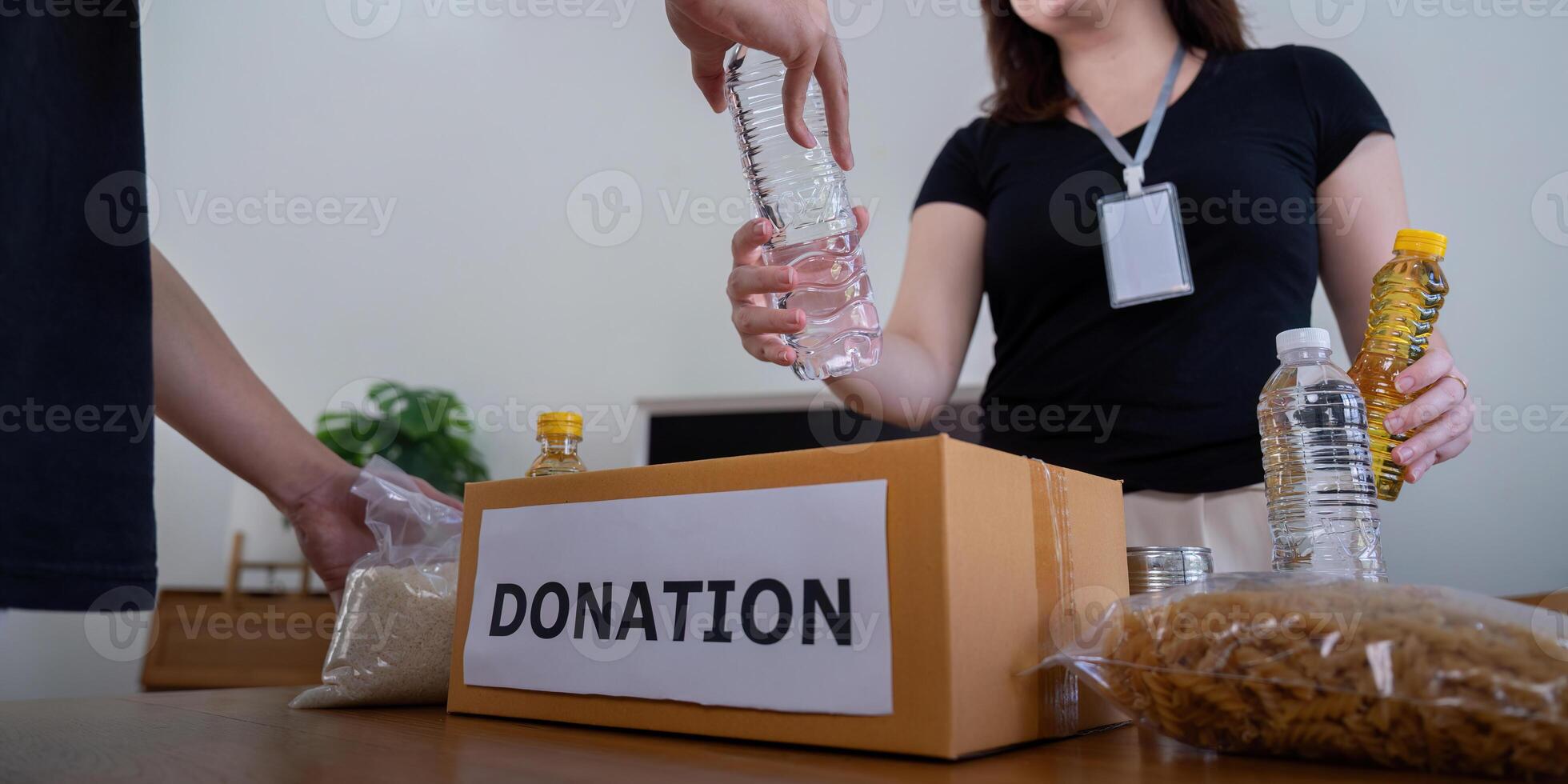 Volunteers Packing Items into Donation Box for Charity photo