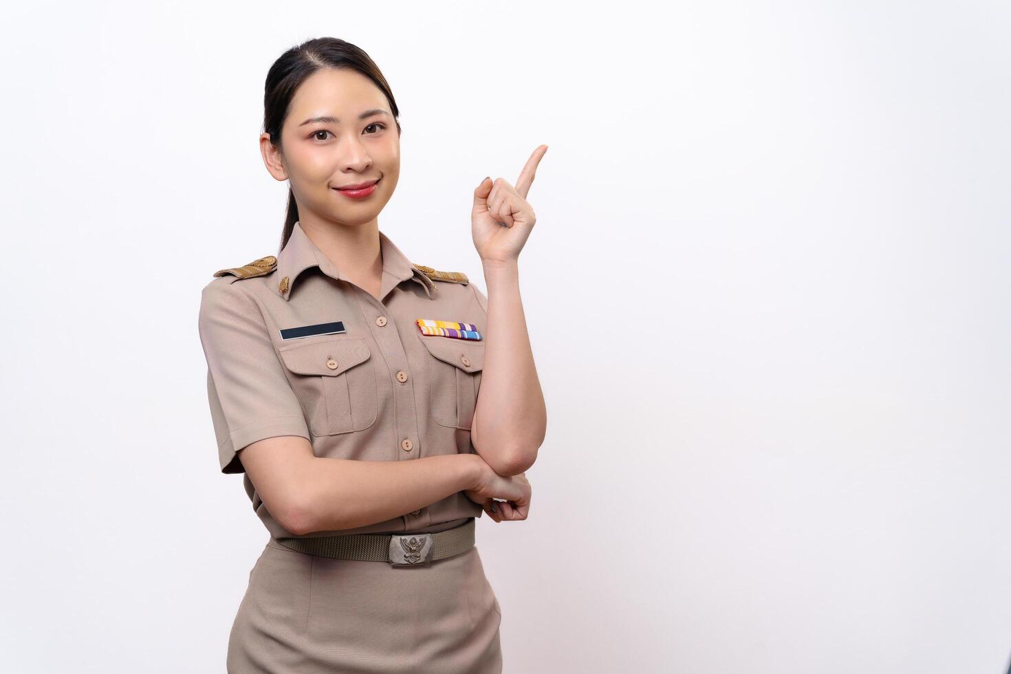 Young Thai Asian Teacher in the uniform is pointing to the empty copy space. photo