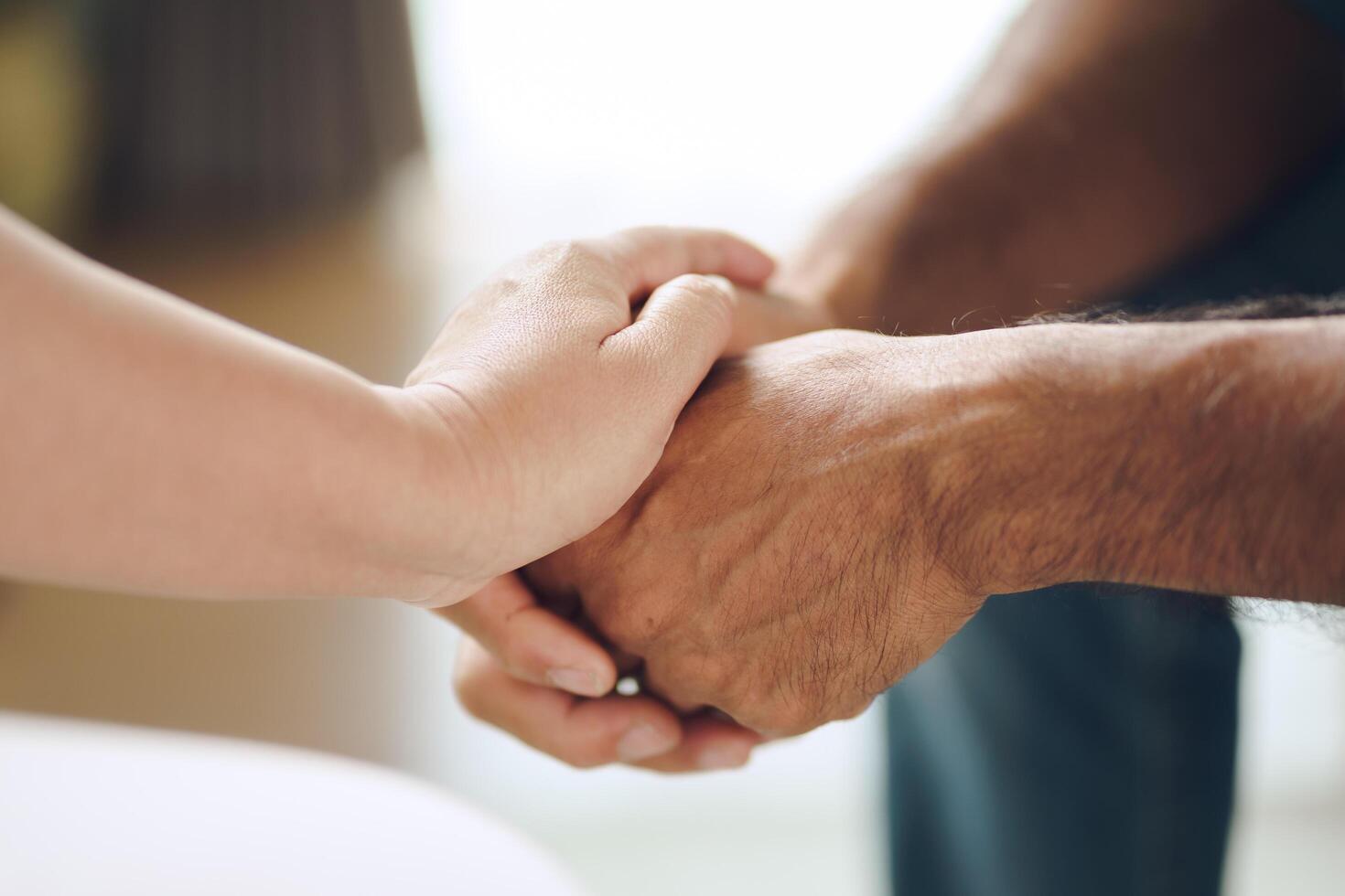 Female friend or family sitting and hold hands during cheer up to mental depress man photo