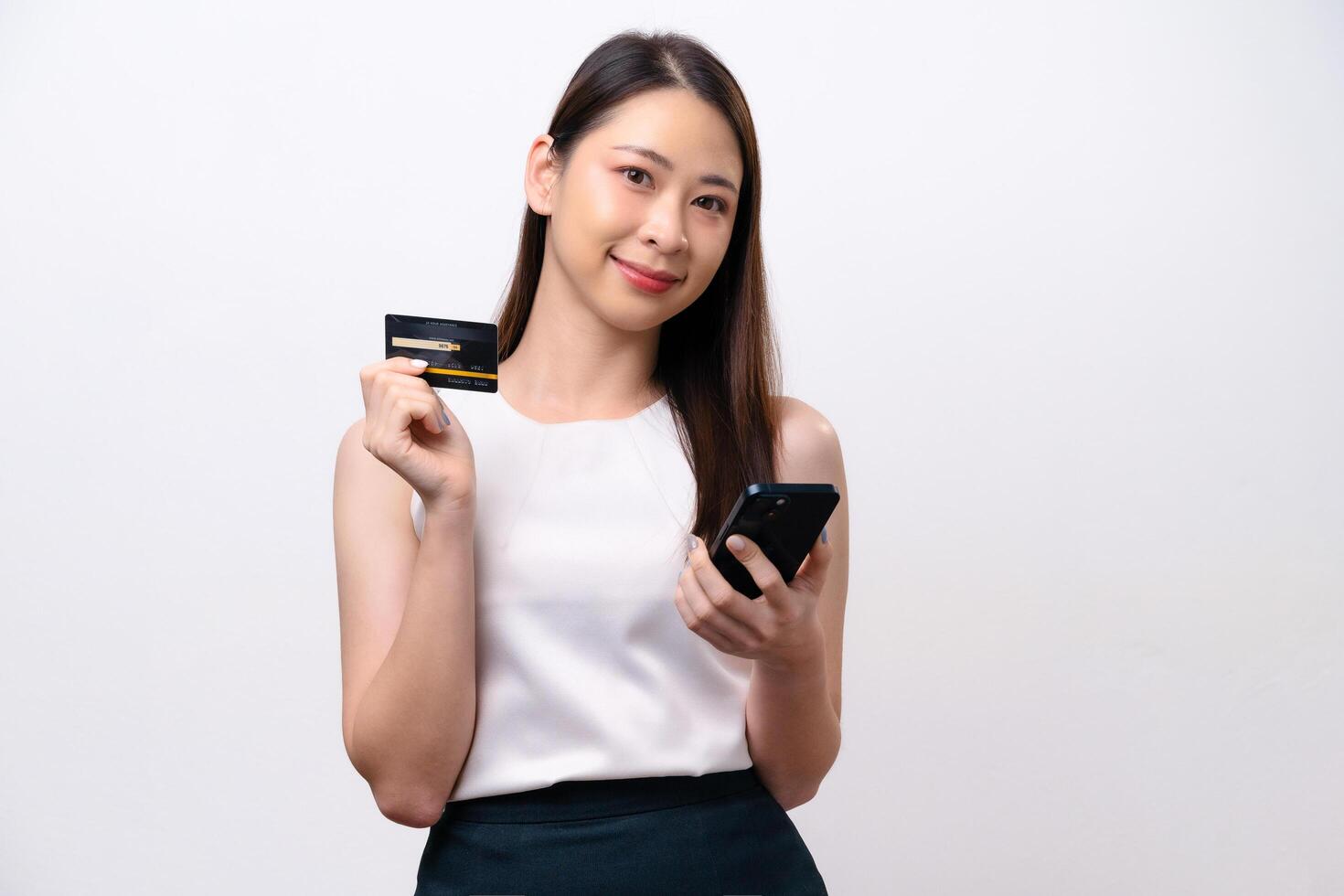 A woman is holding a credit card and a cell phone photo