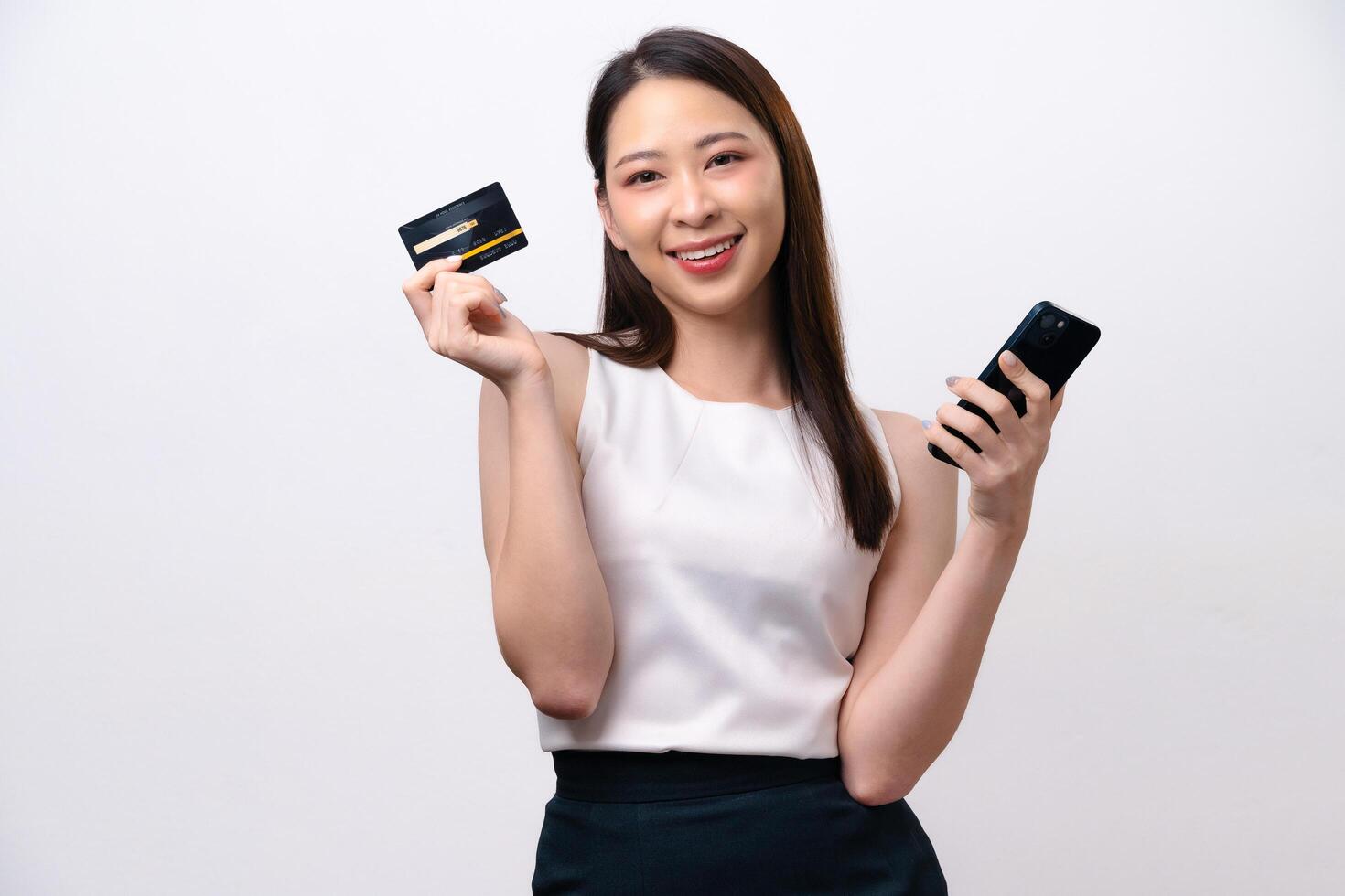 A woman is holding a credit card and a cell phone photo
