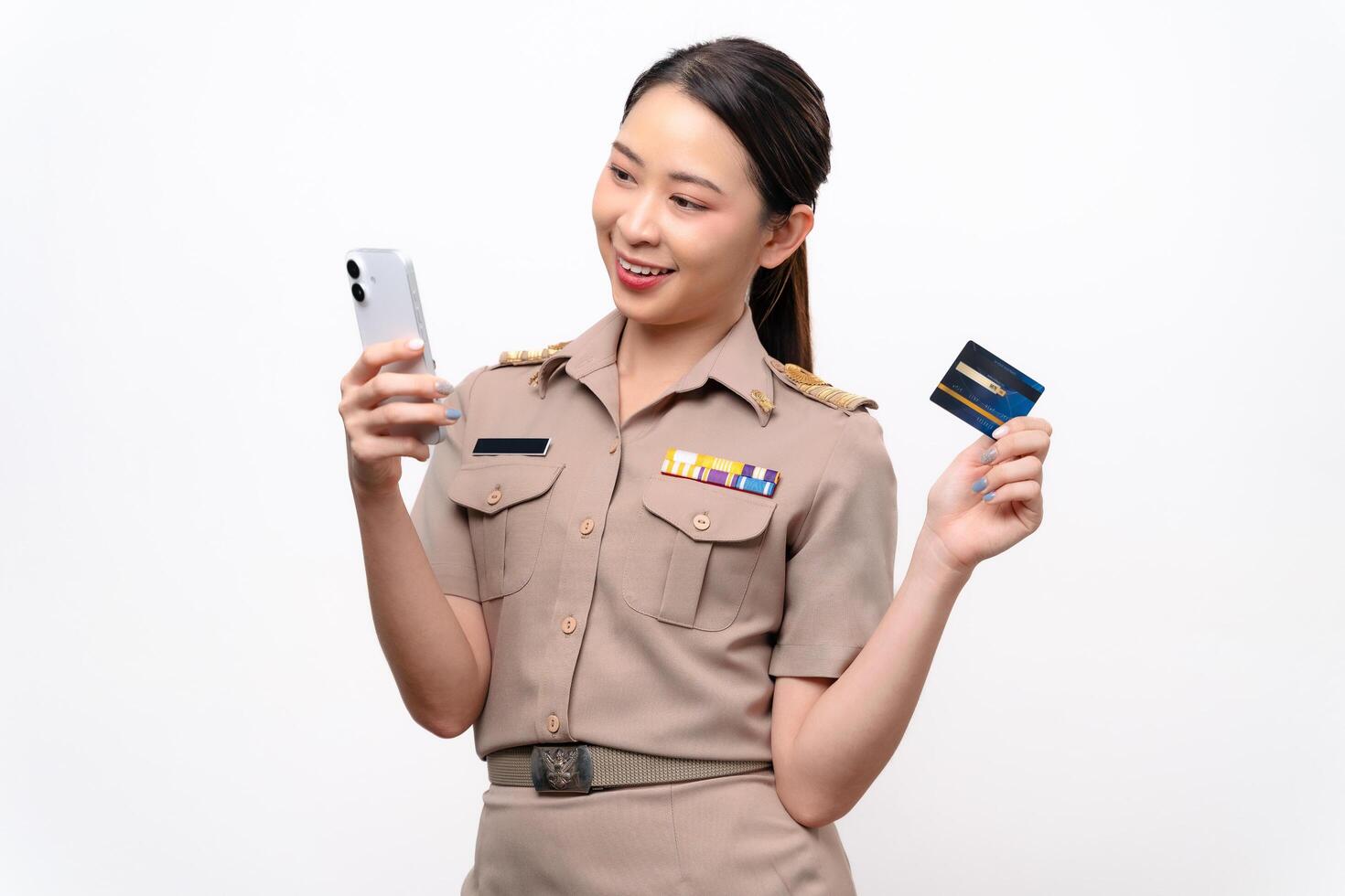 Young Thai Asian Teacher in the uniform is holding the credit card and smart phone. photo